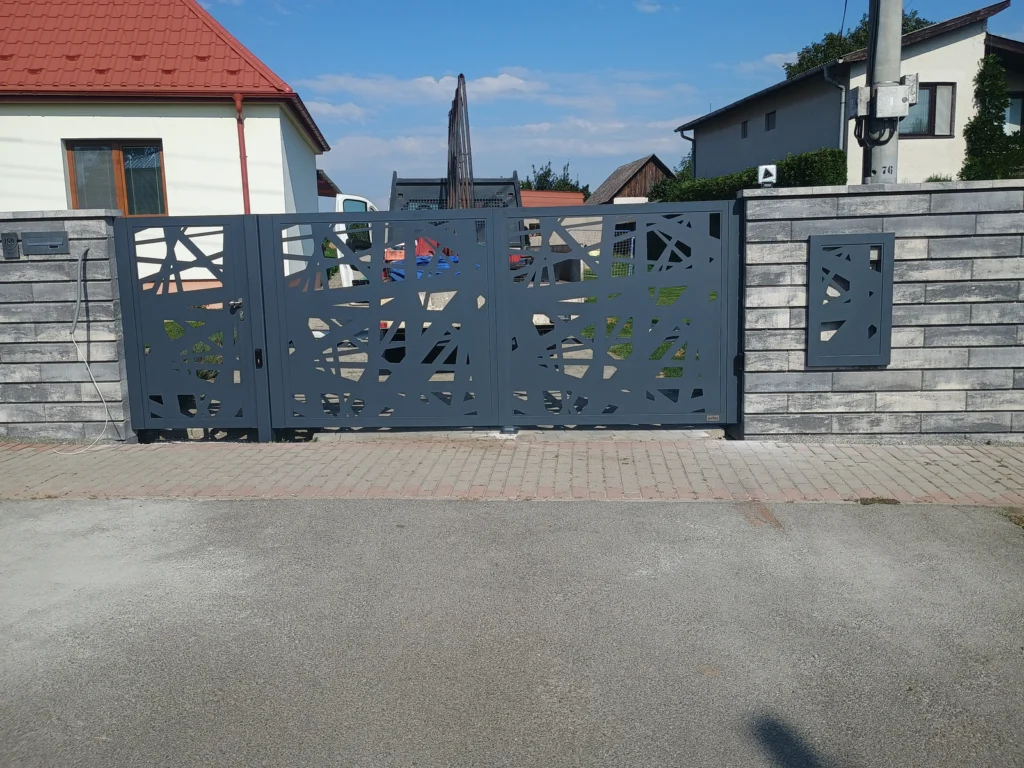 Brána a bránička osadené do murovaného plota z okrasných tvárnic